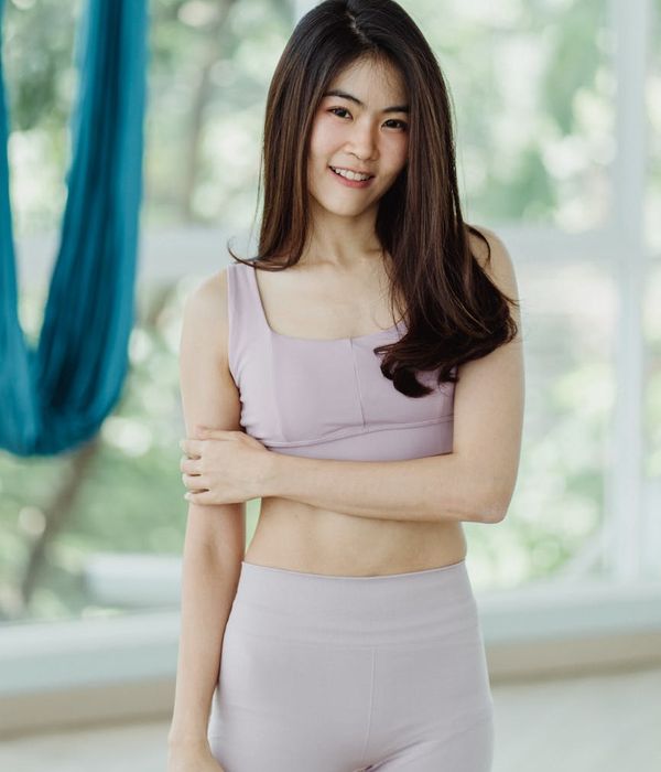 Woman in comfortable clothes smiling after a light exercise session.